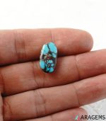Blue Persian turquoise cabochon shown on hand to illustrate real-life size and matrix details.