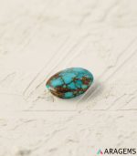 Perspective view of oval Neyshabur turquoise cabochon showing natural dome and matrix pattern.T14 | Aragems