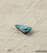 Perspective view of triangular Neyshabur turquoise showing cabochon angles and natural surface polish.t16 - Aragems