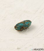 Perspective view of elongated oval Iranian turquoise cabochon highlighting surface polish and matrix.