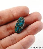 Iranian turquoise cabochon shown on hand to display real-life size and blue-green tone.
