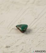 Perspective view of triangular Iranian turquoise cabochon highlighting polish and matrix.