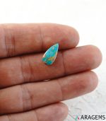 Iranian turquoise cabochon shown on hand to display real-life size.t23-Aragems