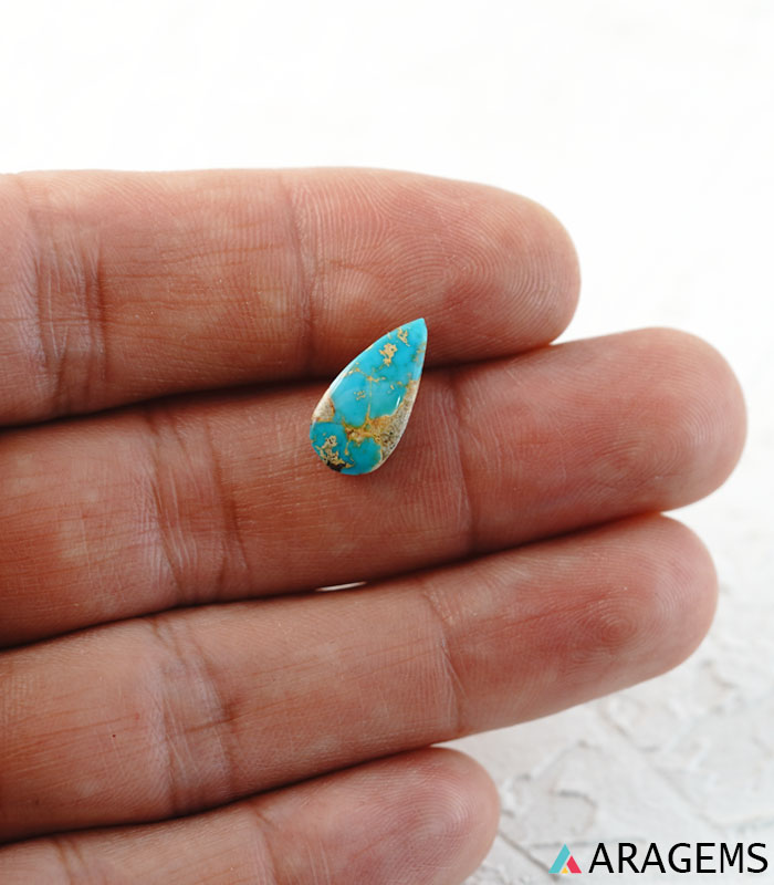 Iranian turquoise cabochon shown on hand to display real-life size.t23-Aragems