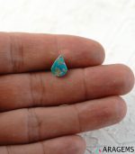 Blue Iranian turquoise cabochon shown on hand for real-life size reference.t26-Aragems
