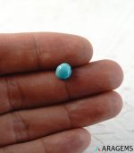 Light blue Iranian turquoise cabochon shown on hand to display real size.T29 | Aragems