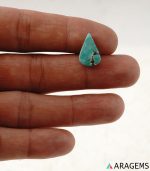 Natural Persian turquoise teardrop cabochon shown on hand to demonstrate real-life size and surface character.t32