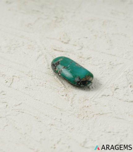 Side view of natural green Kerman turquoise oval cabochon with speckled matrix - T39