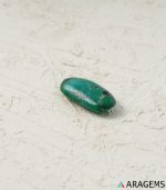 Side view of natural green Kerman turquoise oval cabochon with speckled matrix - T39