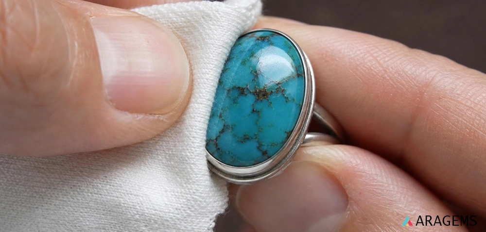Gently cleaning a turquoise cabochon ring with a soft microfiber cloth | Aragems