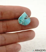 Hand holding natural blue Kerman turquoise teardrop cabochon showing its 17 x 19 mm size - T51