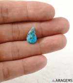 Hand holding natural blue Neyshabur turquoise teardrop cabochon showing its 9 x 15 mm size - T47