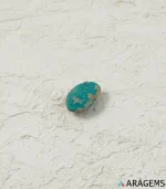 Hand holding natural Neyshabur turquoise oval cabochon showing its 8 x 12 mm size - T48