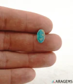 Natural Neyshabur turquoise oval cabochon on a textured white surface, side angle - T48