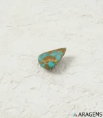 Natural blue Neyshabur turquoise teardrop cabochon on a textured white surface, close angle - T52