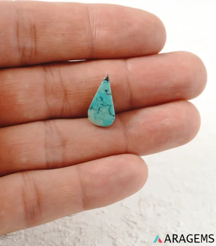Hand holding natural teal Neyshabur turquoise teardrop cabochon showing its 8 x 16 mm size - T53
