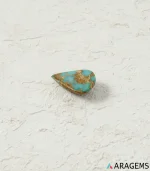 Natural Neyshabur turquoise teardrop cabochon on a textured white surface, side angle - T52