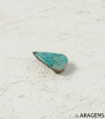 Natural Neyshabur turquoise teardrop cabochon on a textured white surface, side angle - T53