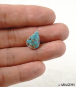 Hand holding natural blue Neyshabur turquoise teardrop cabochon showing its 11 x 15 mm size - T54